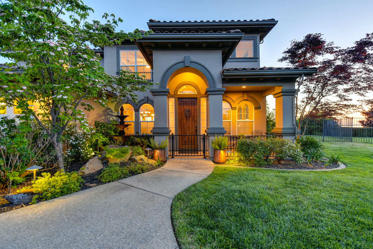 A beautifully landscaped front yard of a luxury home